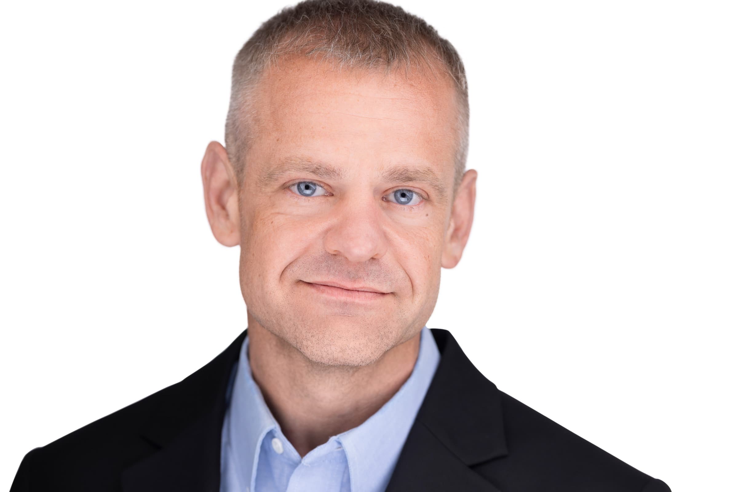 Professional corporate headshot of a man in a dark suit on a clean background, photographed in St. Louis