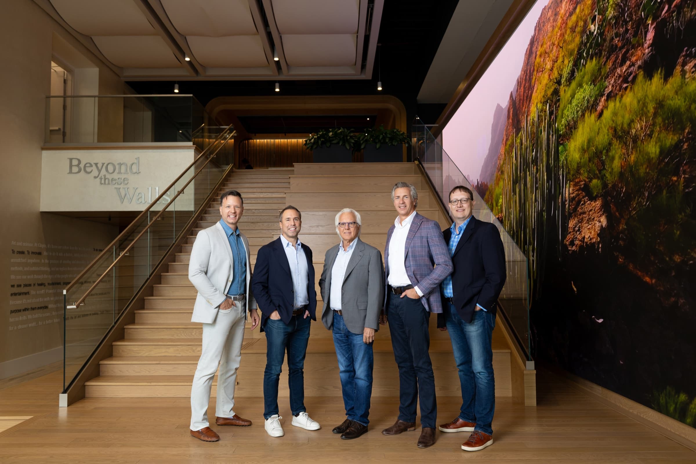 Five business leaders standing together on a modern open office staircase at Clayco in St. Louis